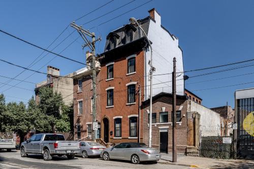 费城Alina & Fanny - Philadelphia Northern Liberties的一座古老的砖砌建筑,前面有汽车停放