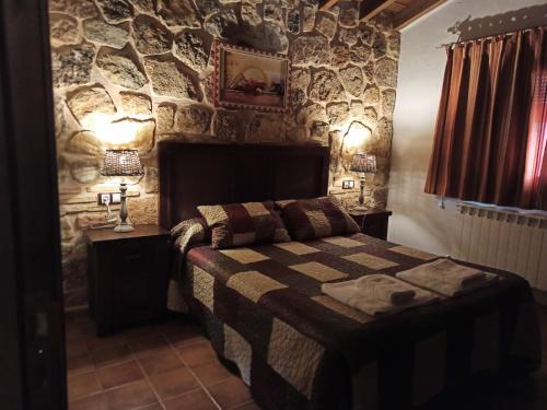里奥帕尔Casas Rurales Majana的卧室配有一张石墙床