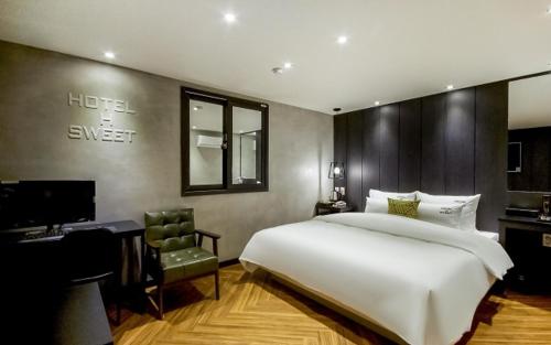釜山Hotel the Sweet的卧室配有一张白色大床和一张书桌