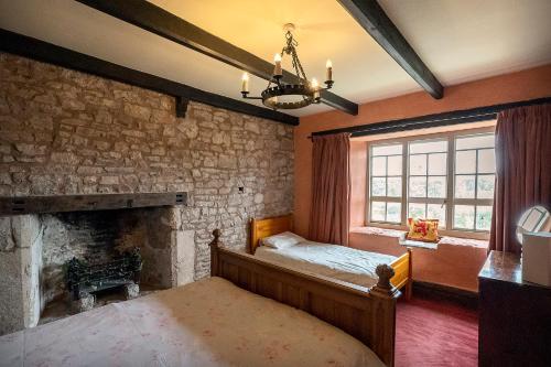 卡尔迪科特Medieval Manor的一间卧室设有一张床和石墙