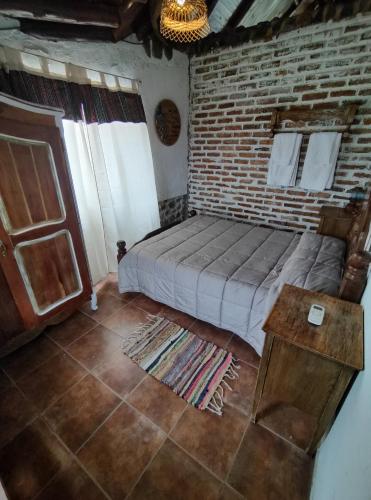 波特雷里约斯Cabañas El Molino的一间卧室设有一张床和砖墙