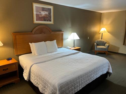 法尔Americas Best Value Inn Pharr/McAllen的酒店客房带一张大床和一把椅子