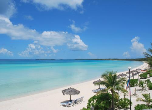 James CisternCocodimama Resort Hotel Room的海滩上设有椅子和遮阳伞,还有大海