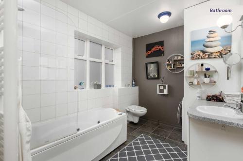 哈纳弗约德尔Private room in Hafnarfjordur的带浴缸、卫生间和盥洗盆的浴室