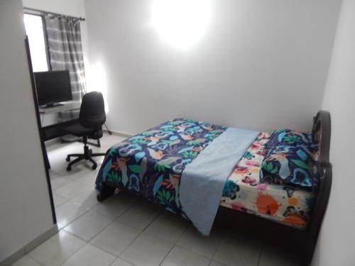 布卡拉曼加Excelente ubicación的一间卧室配有一张床和一张带电脑的书桌
