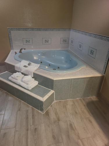 法尔Americas Best Value Inn Pharr/McAllen的浴室配有带毛巾的大浴缸。