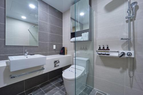全州市Jeonju Signature Hotel&Residence的浴室配有卫生间、盥洗盆和淋浴。