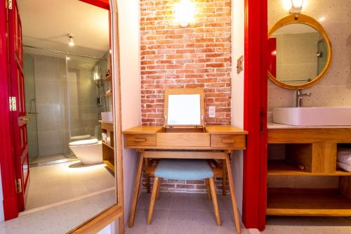 胡志明市Leiden Homestay&Cafe'的浴室配有盥洗盆和带镜子的梳妆台