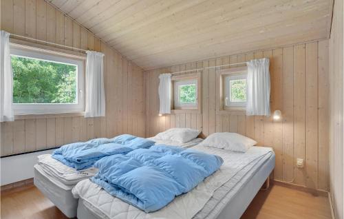 比戈Awesome Home In Vig With 3 Bedrooms And Wifi的一张大床,位于带两个窗户的房间