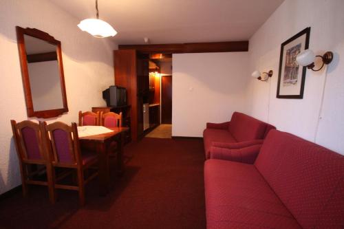 布尔泽策ApartHotel Kopaonik的酒店客房设有沙发、桌子和镜子