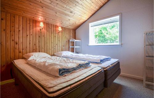 伦德Stunning Home In Rnde With 3 Bedrooms And Wifi的木墙客房的两张床