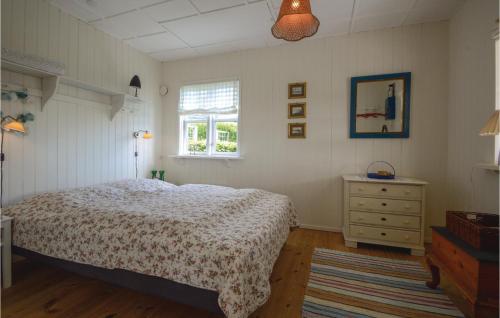海耶斯Cozy Home In Hejls With Wifi的一间卧室配有一张床、一个梳妆台和一扇窗户。