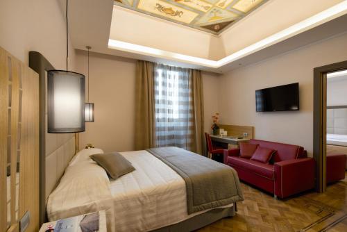 罗马Vibe Nazionale的酒店客房,配有一张床和一张红色椅子