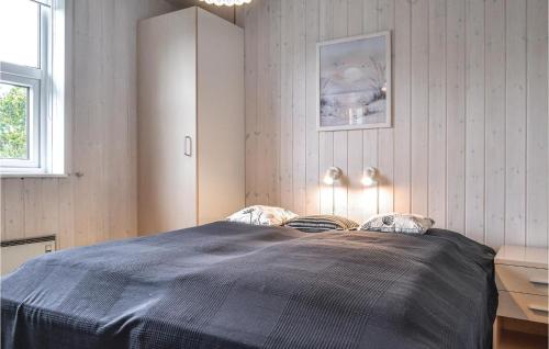 NymindegabAwesome Home In Nrre Nebel With Wifi的一间卧室配有一张带蓝色毯子的大床