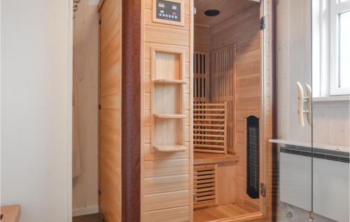 NymindegabAwesome Home In Nrre Nebel With Wifi的一间设有木制衣柜的房间,里面装有时钟