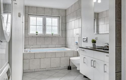 博恩瑟Awesome Apartment In Bogense With House Sea View的带浴缸、卫生间和盥洗盆的浴室