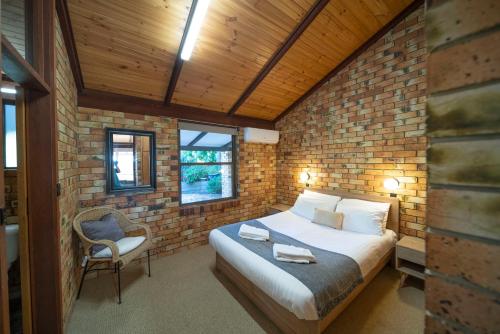 贝瑟尼Blickinstal Holiday Retreat的一间卧室设有一张床和砖墙