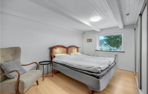 锡尔克堡Cozy Home In Silkeborg With Kitchen的卧室配有床、椅子和窗户。