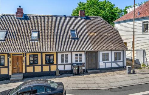 斯文堡Nice Home In Svendborg With Wifi的一座黄色和白色的房子,前面有一辆汽车