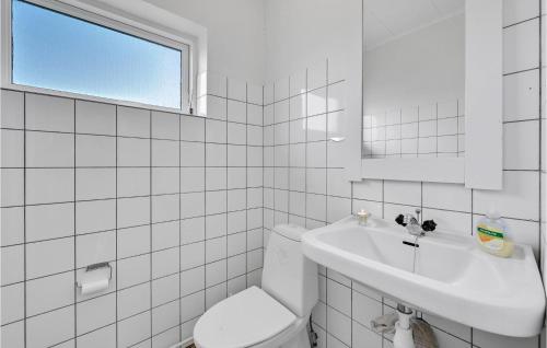 Nymindegab诺力纳贝尔21号度假屋的白色瓷砖浴室设有卫生间和水槽