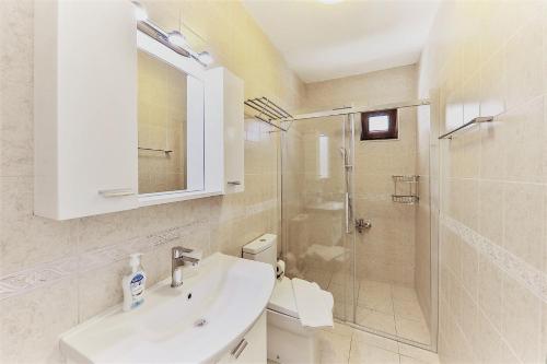 卡尔坎Villa Tymnessos的白色的浴室设有水槽和淋浴。