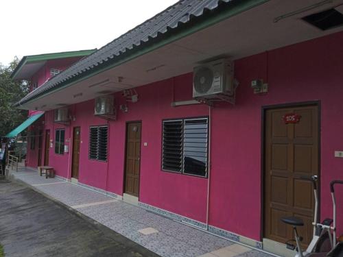 芭东海滩Baan Nakarin Guest House บ้านนครินทร์的粉红色的建筑,有门,缺氧