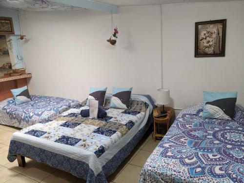 阿拉胡埃拉Guesthouse Casa Lapa2的一间卧室配有两张床和一张带台灯的桌子