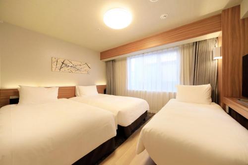 名古屋名古屋新干线口里士满酒店的酒店客房设有两张床和窗户。