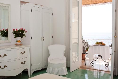 波西塔诺塔尔谭纳别墅酒店的白色的房间,配有椅子和梳妆台