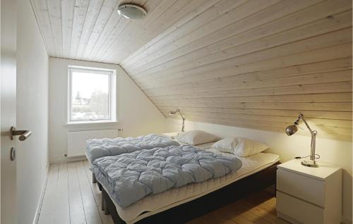 ØstermarieCozy Home In stermarie With Kitchen的一张位于带木制天花板的客房内的大床