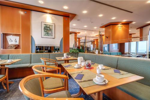 开姆尼茨Congress Hotel Chemnitz的配有木桌和椅子的餐厅