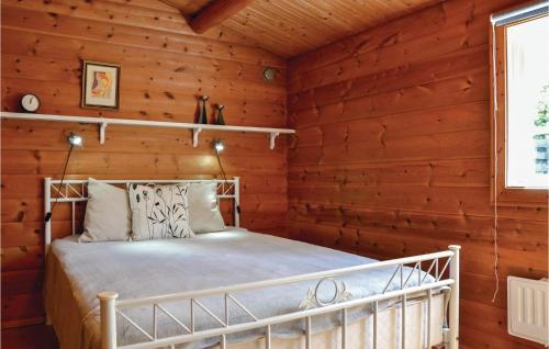 BakkegårdeNice Home In Jgerspris With Wifi的小木屋内一间卧室,配有一张床