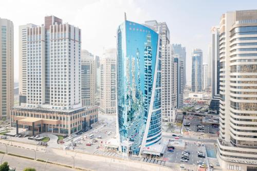 多哈Qabila Westbay Hotel by Marriott的一座高大的蓝色建筑,在城市里