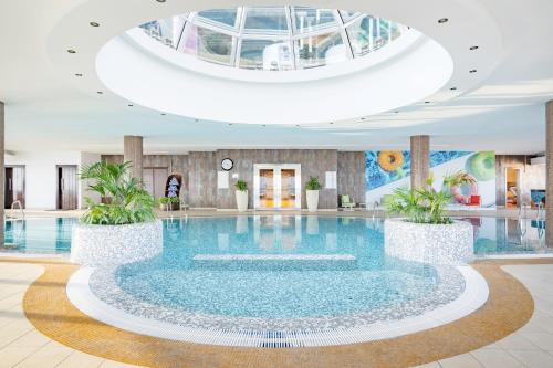 多哈Qabila Westbay Hotel by Marriott的酒店大堂的大型游泳池,设有圆顶天花板