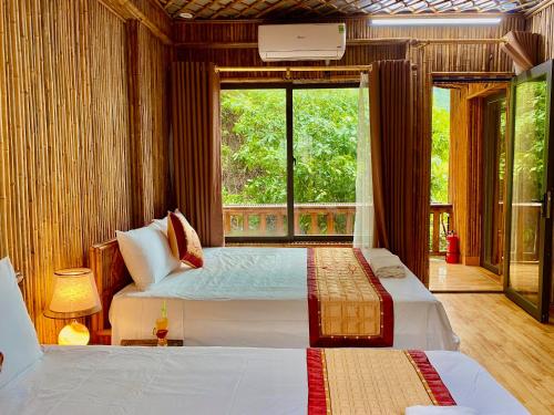宁平Bamboo Hill Villa的一间卧室设有两张床和大窗户