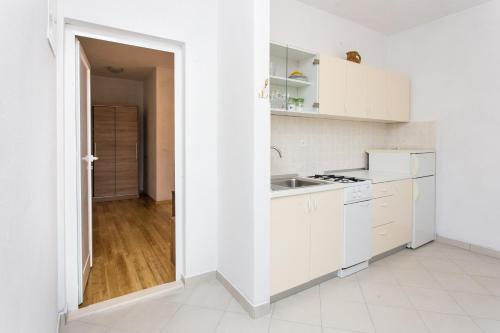 科洛塞普Guest House Oreb的白色的厨房配有白色橱柜和水槽