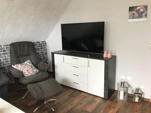 帕彭堡Haus Eierhof的客厅配有平面电视和椅子。
