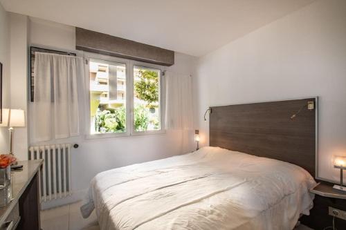 戛纳Croisette: 2BDR Apartment的一间卧室设有一张大床和一个窗户。