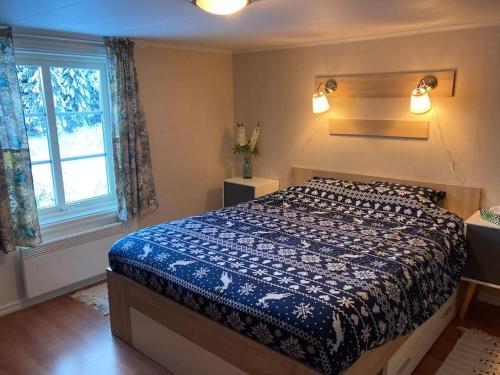 希塞里贝克Branäs Holiday Home的一间卧室配有一张带蓝色棉被的床和窗户。