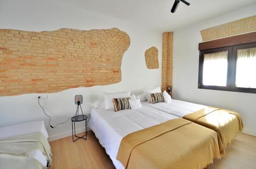 格拉纳达Casa Limon, Patio y Parking.的一间卧室设有一张大床和砖墙