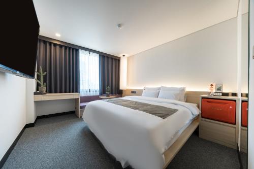 首尔Jamsil Stay Hotel的酒店客房设有一张大床和一台电视。