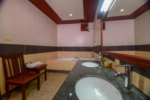 Muang KhôngSenesothxuene Hotel的带浴缸、水槽和椅子的浴室