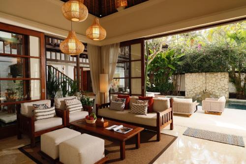 金巴兰Jimbaran Beach Villas by Nakula的客厅配有许多家具和窗户。