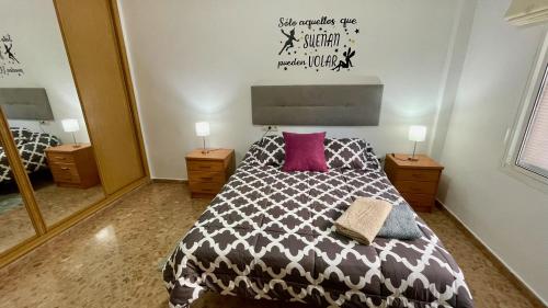 马拉加Palacio de Ferias apartamento的一间卧室配有一张带黑白色棉被的床