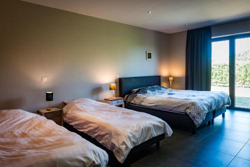 Sint-Gillis-WaasVakantiehoeve Berckelaer的酒店客房设有两张床和窗户。