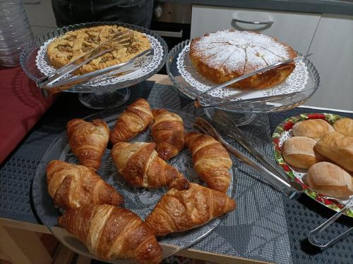 菲纳莱利古雷La Rosa Dei Venti的桌上放着一束羊角面包和其他糕点