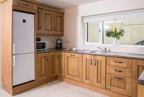KillalaIsland Winds Along The Atlantic Way的厨房配有木制橱柜和白色冰箱。