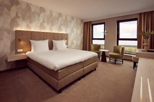 霍林赫姆Van der Valk Hotel Gorinchem的配有一张床和一把椅子的酒店客房