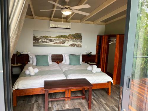 DivunduWhite Sands Lodge的一间卧室配有一张带桌子的床