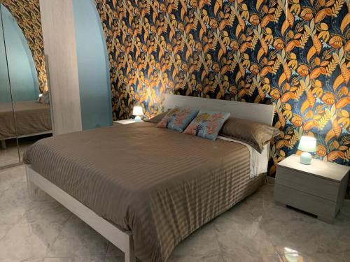 卡诺萨迪普利亚Casa - Torre dell'Orologio的一间卧室配有一张带花卉壁纸的大床